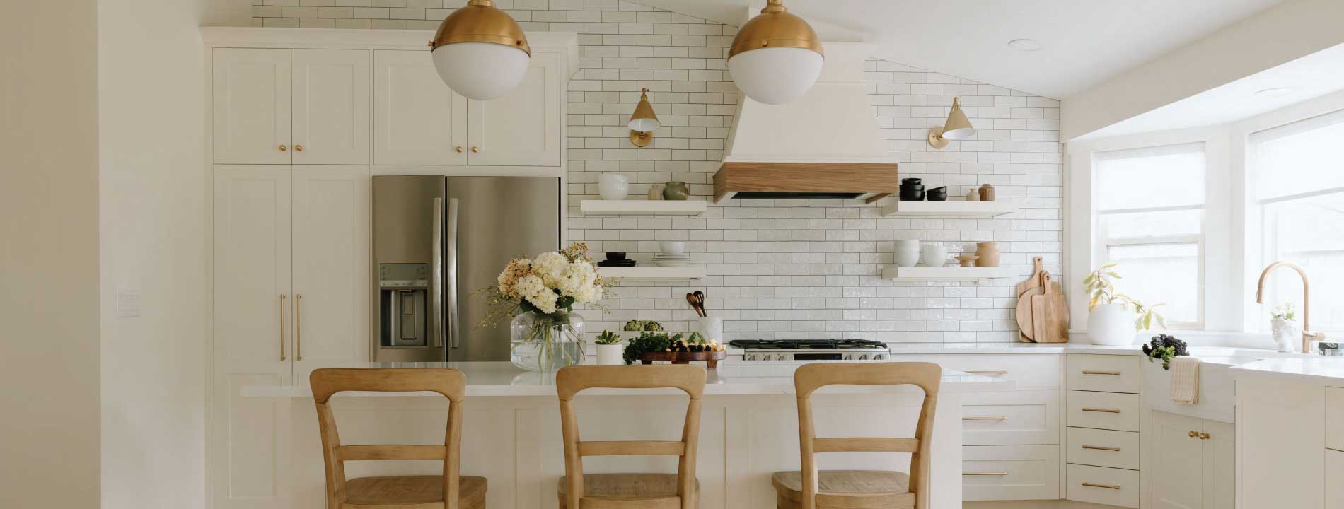 Beautiful TruStone Homes kitchen with white cabinetry and brass fixtures